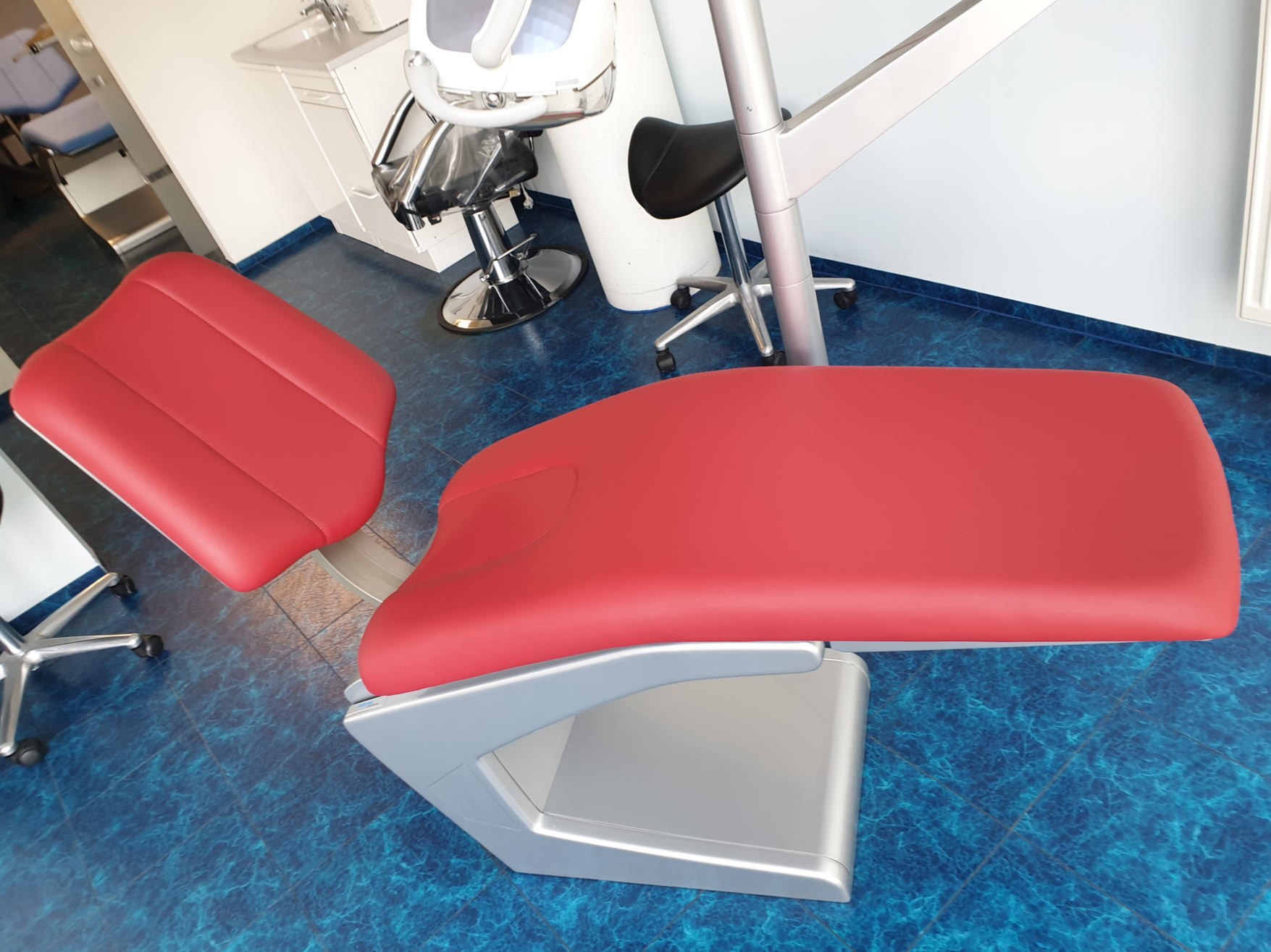 Roter Behandlungsstuhl mit neuem Bezug