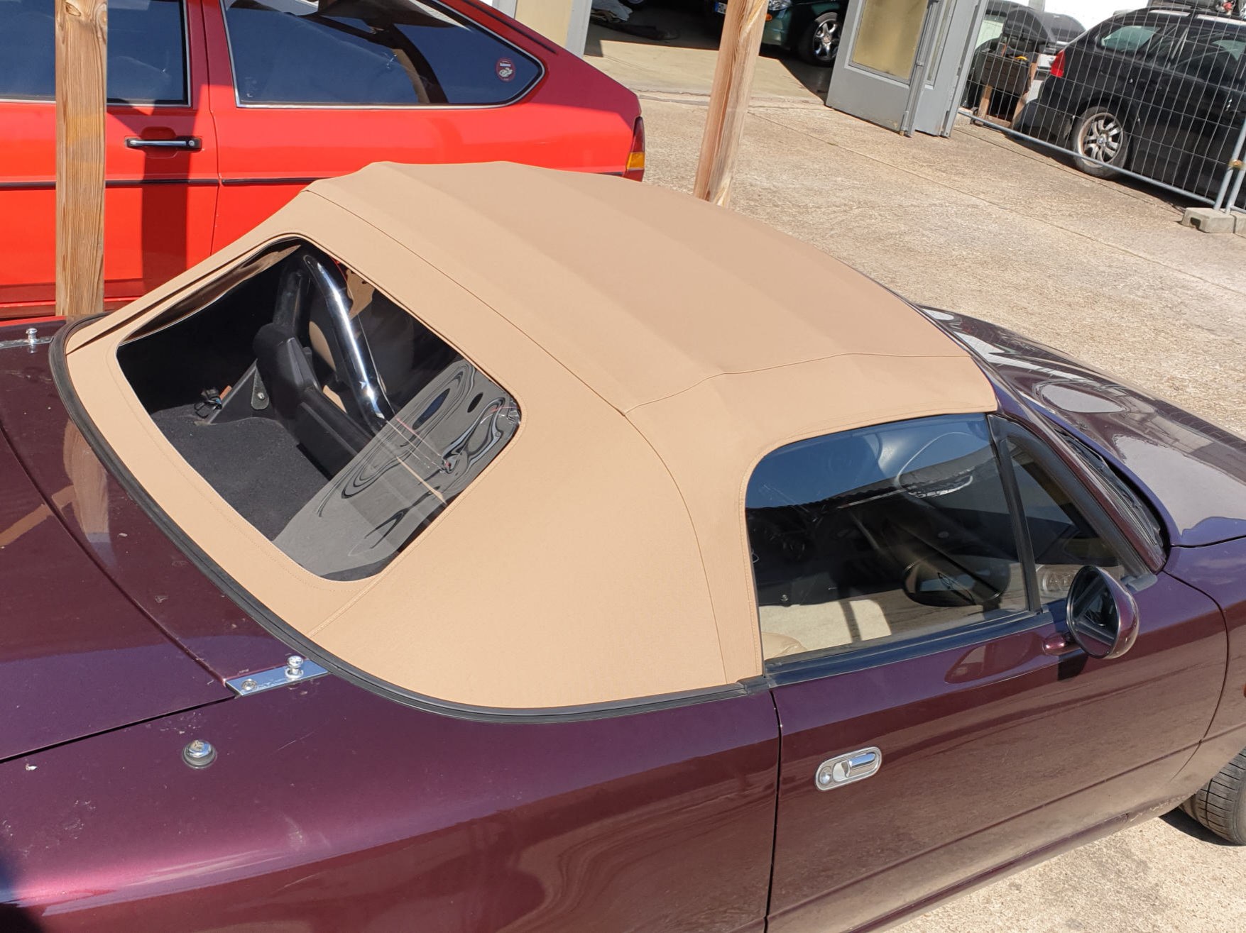 Dunkelrotes Cabriolet mit hellem Verdeck